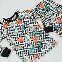 personalized halloween PJ's that have ghosts and skateboards and jack-o-lanterns on a black and white checkered background and black cuffs.