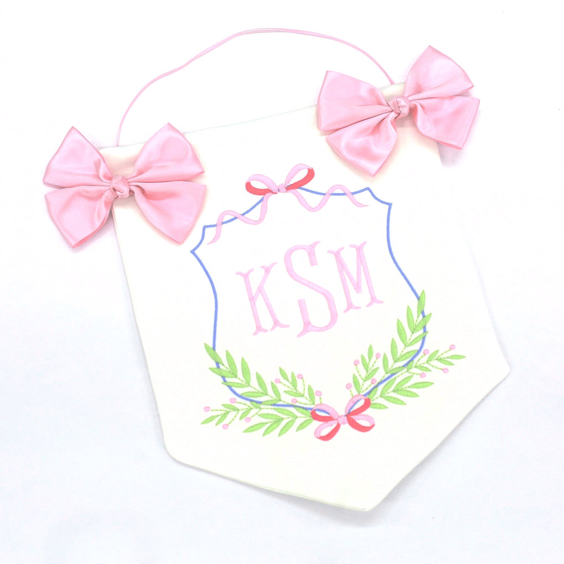 white and pink door hanging banner with baby's embroidered initials, two pink bows and a string for hanging on nursery or hospital door.