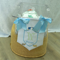 white satin door hanger for baby nursery or hospital room on the end of a newborn bassiet, blue bows on the corners, hanging string, embroidered initial and name with golf clubs and ball