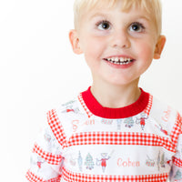 Little boy wearing personalized Modern Nutcracker Ballet for little boys with minimalistic images from the Nutcracker Ballet and his name with red checkered stripe pattern on white background and red cuffs.