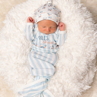 baby in a coastal inspired blue striped baby gown with little crabs, baby's name and tie bottle closure