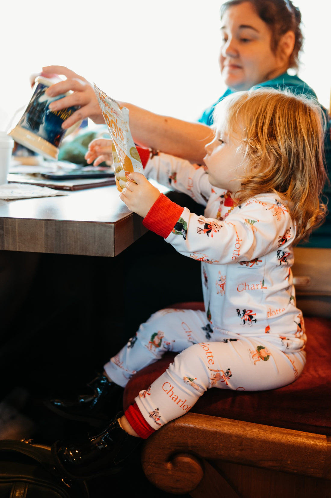 little girl wearing kids custom pajamas with christmas puppies in boys and wreathes with their name, red cuffs