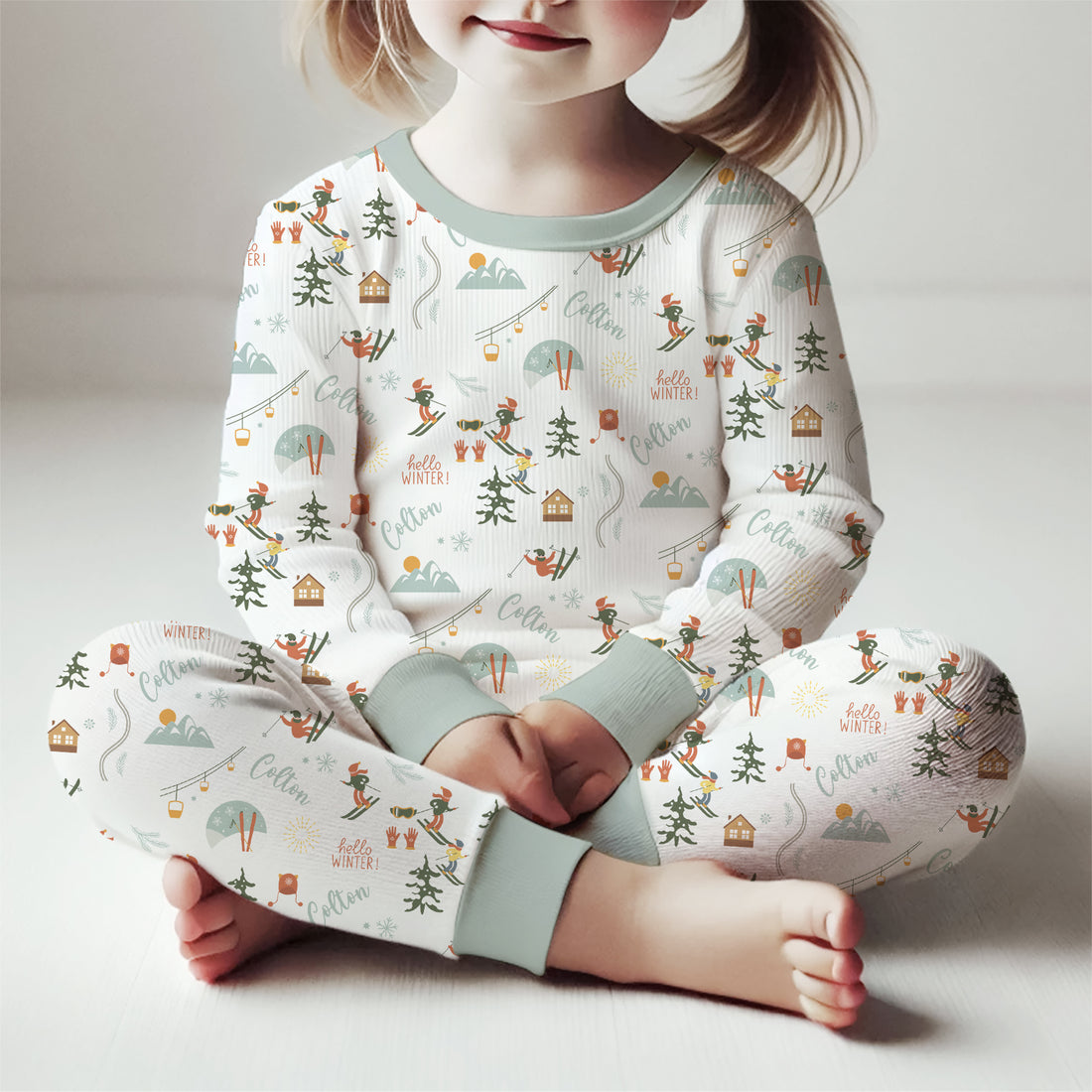 Young girl sitting and wearing Ski Pajamas.