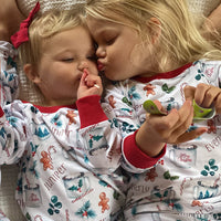 Two children wearing matching hot cocoa christmas pajamas