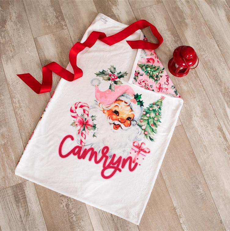 Minky fabric Christmas pillowcase for girls with vintage Santa face and pink accents and kid's name in red script font.