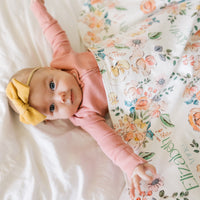 Baby wrapped in personalized keepsake blanket with satin trim
