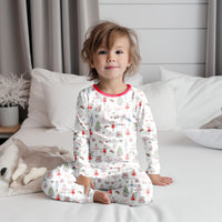 baby wearing personalized Modern Nutcracker Ballet pajamas, featuring minimalistic images from the iconic nutcracker ballet among child's name on white fabric with red cuffs.