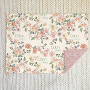 minky baby blanket with pastel colorful flowers in a sketched look with baby's name on the front side, and pink minky faux fur on the back