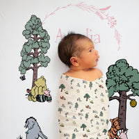 Baby Girl laying on Winnie The Pooh Crib Bedding