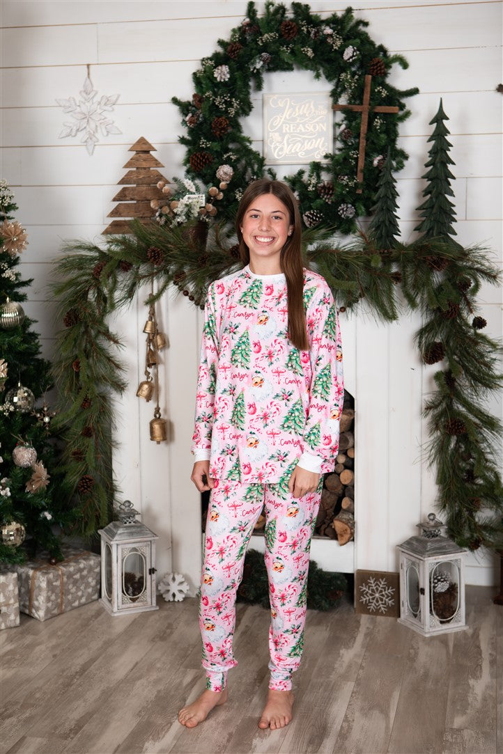 Adult standing in front of the fire place wearing her Pink Santa Pajamas.