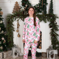 Adult standing in front of the fire place wearing her Pink Santa Pajamas.