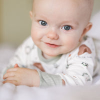 Personalized Kids Pajamas Custom Made, baby wearing personalized He is Risen Easter PJs with Biblical Easter images on a white stretchy knit fabric, perfect for babies toddlers and big kids.