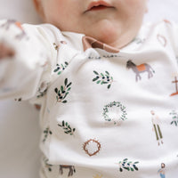 baby wearing personalized He is Risen Easter PJs with Biblical Easter images on a white stretchy knit fabric, perfect for babies toddlers and big kids.