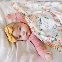 Baby wrapped in personalized keepsake blanket with satin trim
