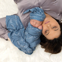Little baby laying next to mom in a camden smokey blue swaddle blanket.