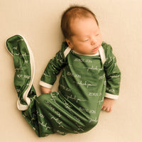 A baby sleeping in a camden olive green baby gown.