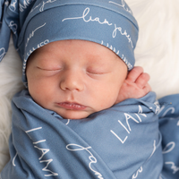 A baby peacefully sleeping swaddled in their personalized camden stretchy swaddle blanket.