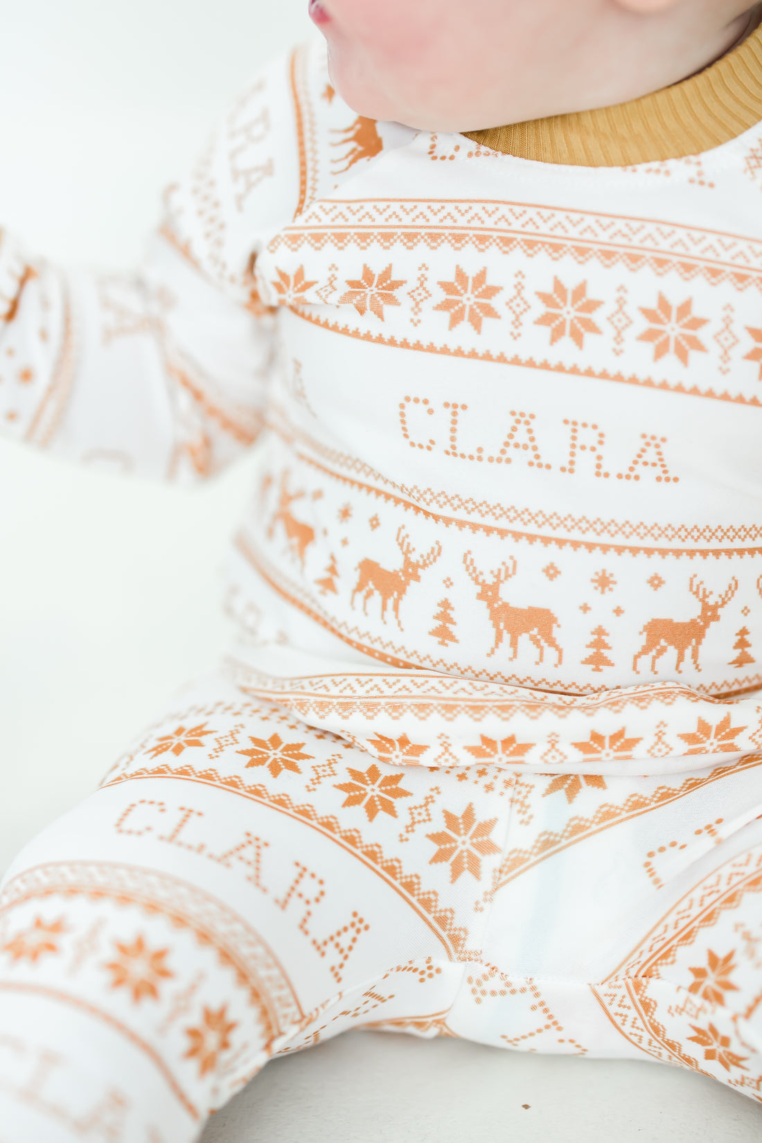 Little baby wearing personalized striped Christmas pajamas.