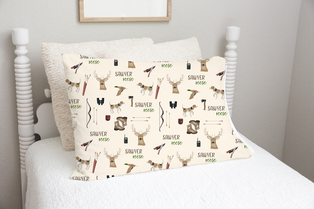 little boy minky pillowcase personalized with his name and deer hunting images such as deer heads, dogs, bow with arrows, boots, and tools.