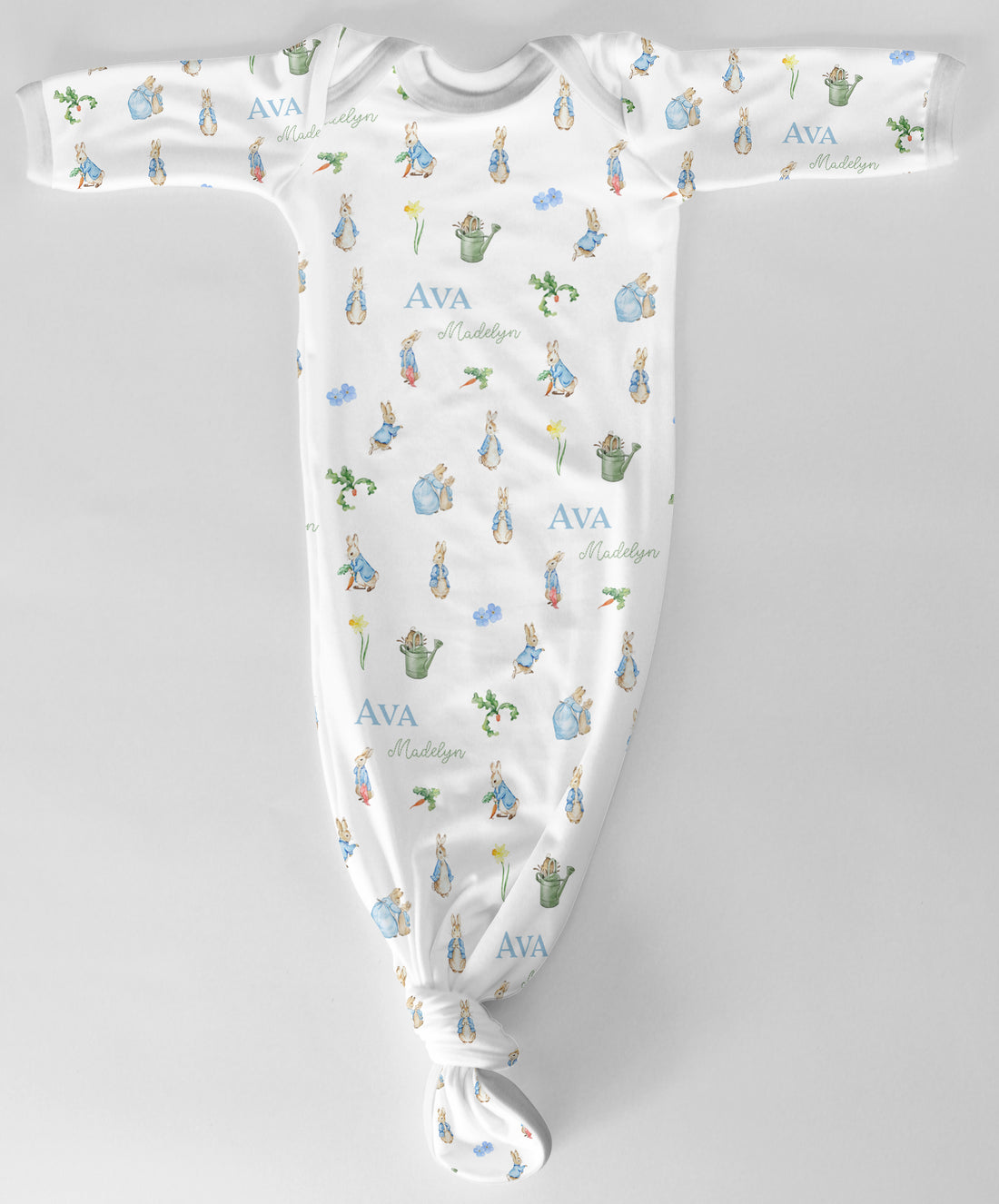 Baby onesie with Peter Rabbit character print and baby's name text on a white fabric background
