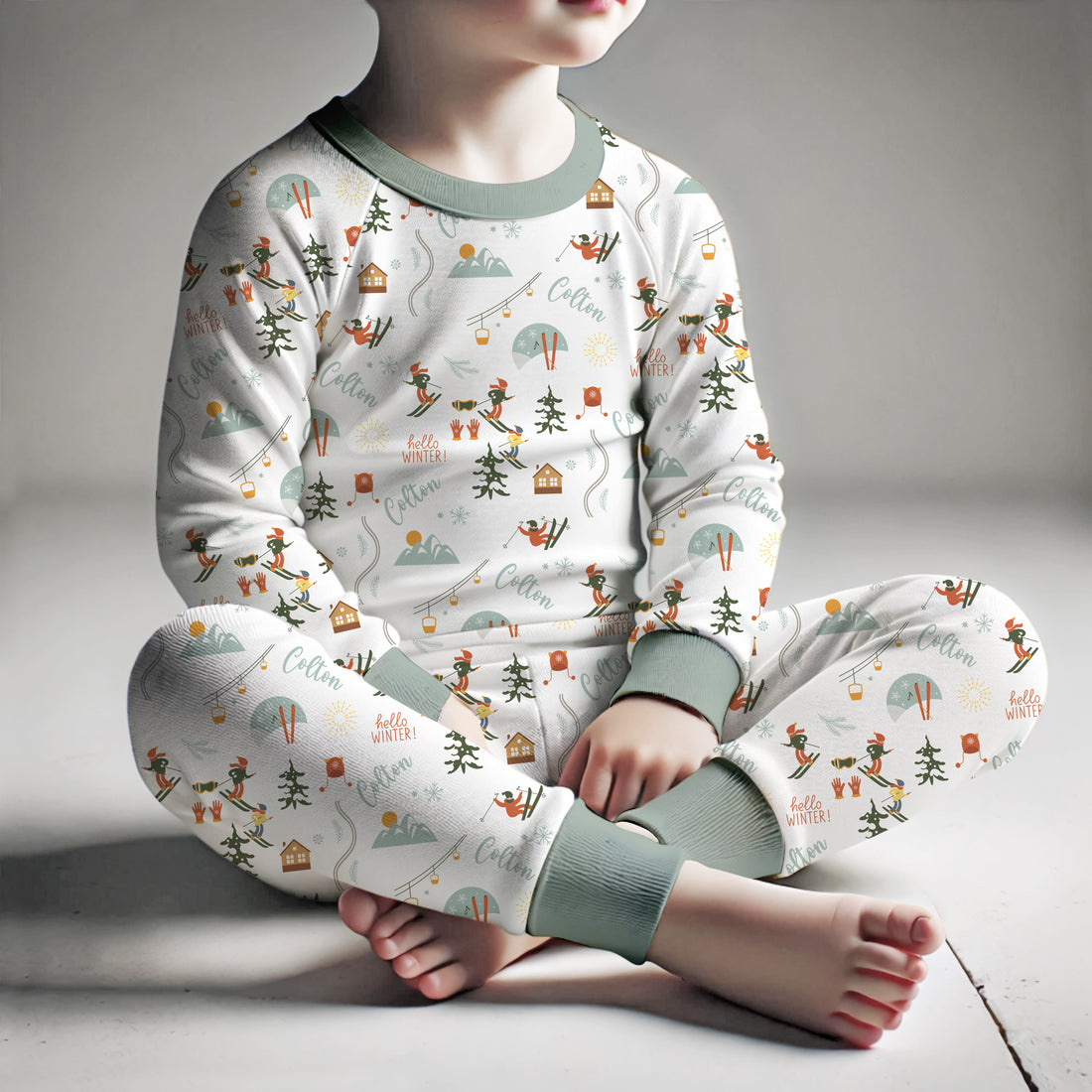 Boy sitting down and wearing personalized ski pajamas.
