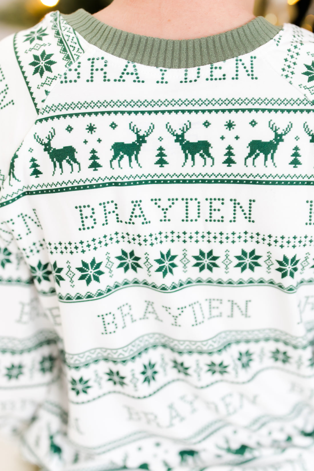 Little boy wearing personalized striped Christmas pajamas with his name on it.