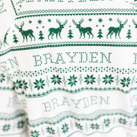 Little boy wearing personalized striped Christmas pajamas with his name on it.