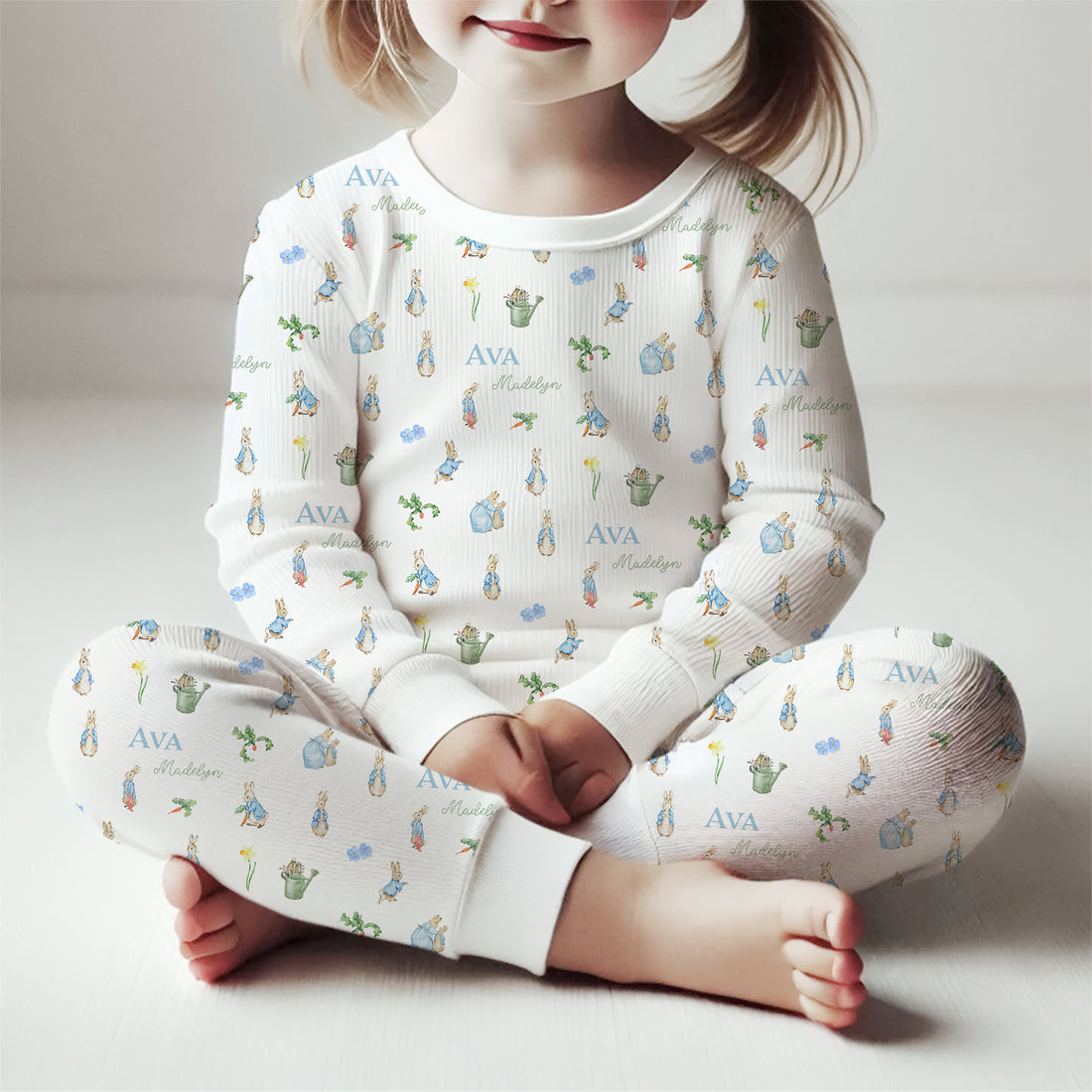 little girl wearing Peter Rabbit character pajamas with white background and child's name.