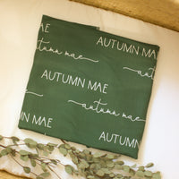 The design and font on our personalized stretchy olive green swaddle blankets.
