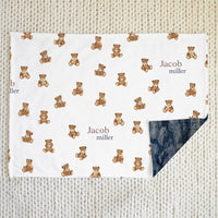 white minky baby blaket with brown teddy bears and baby's name in text on the front, and navy blue minky plush fur on the back