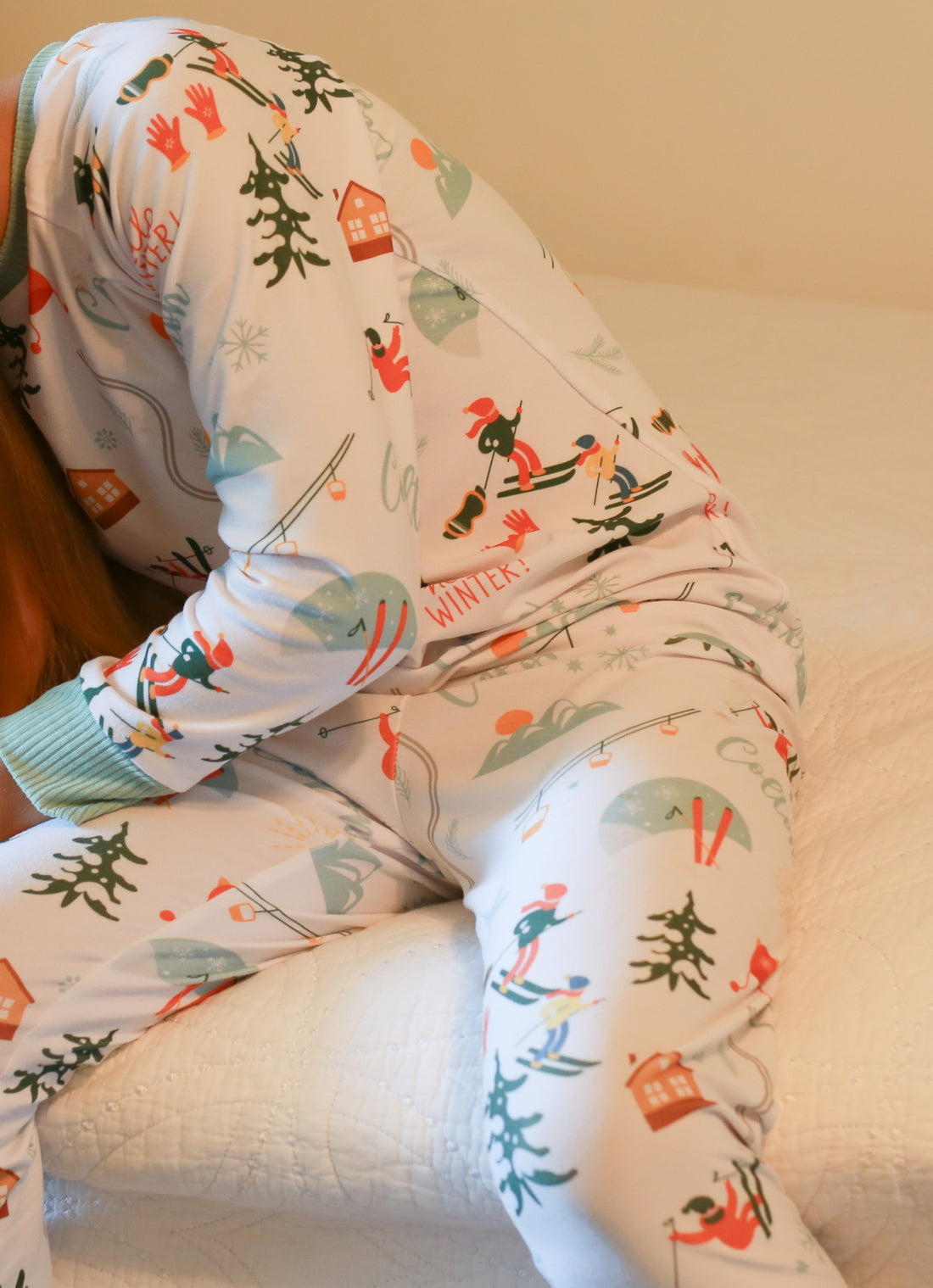 Child sitting in chair while wearing Ski Pajamas.