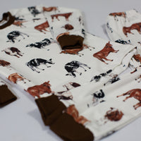 A close up look at the design on our kids cow pajamas. The design has brown and black cows with the brown cuffs on the shirt and pants to match the cow design.