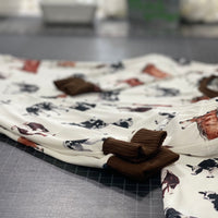 Our personalized cow pajamas nicely folded laying on a black table. The design on the pajamas has three different cows along with brown cuffs on the shirts and pants that matches the design.