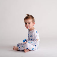 Little boy wearing personalized kids Hanukkah pajamas that have blue and gold cookie.