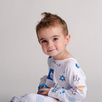 Boy wearing kids Hanukkah pajamas.