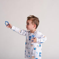 Kids playing while wearing kids Hanukkah Pajamas.