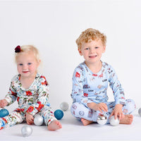 little boy wearing Letters to Santa Christmas pajamas, Holiday images along with letters and mailboxes among our child's name on a light blue background.