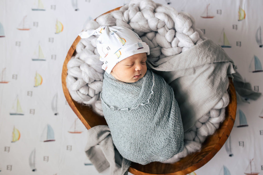 Baby sleeping in their personalized sailboat swaddle.