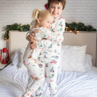 A brother and sister wearing matching Gingerbread Christmas Pajamas.