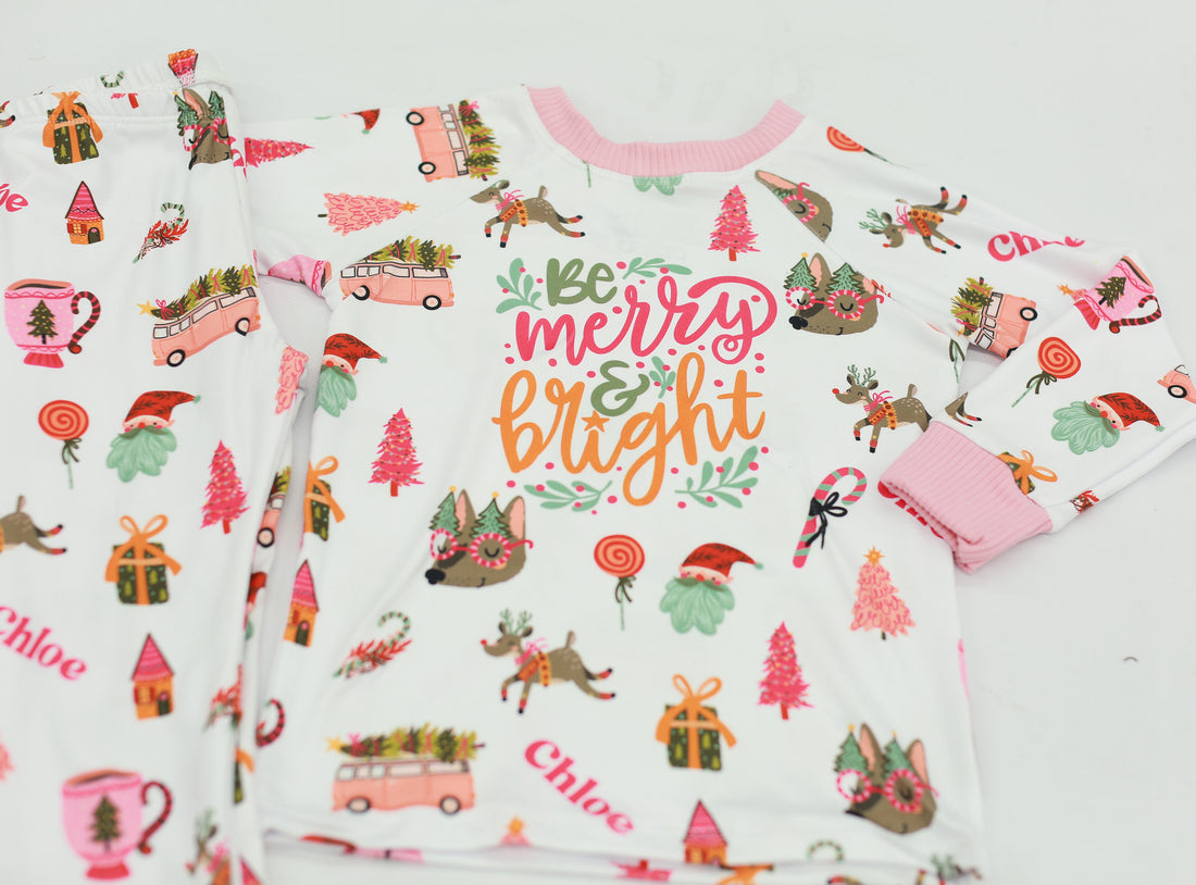 Merry & Bright colorful christmas jammies, with pink and green cartoon Holiday images such as trees, lollipops, Santa faces, candy canes and reindeer.