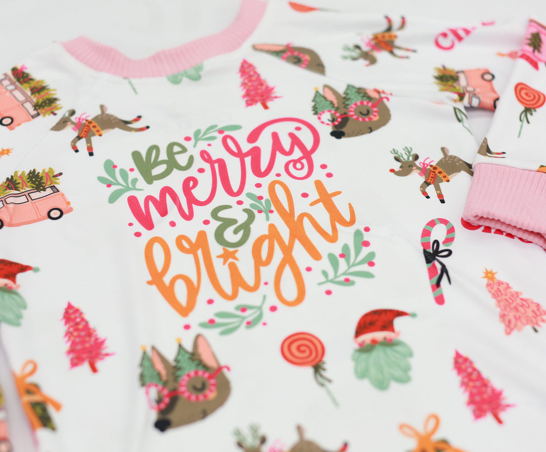 Merry & Bright colorful christmas jammies, with pink and green cartoon Holiday images such as trees, lollipops, Santa faces, candy canes and reindeer.