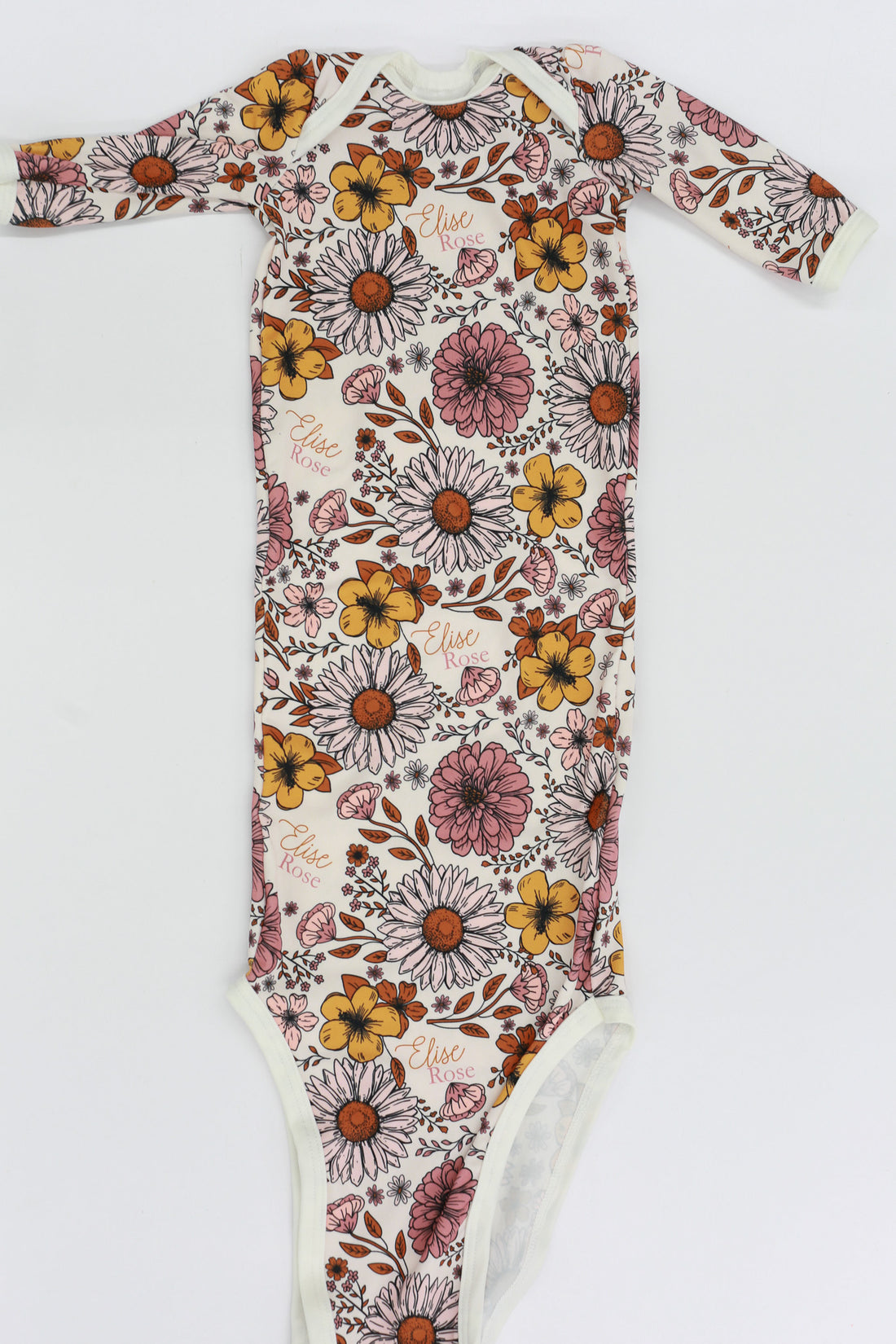A long-sleeved onesie with a floral print pattern, featuring various colors and shapes of flowers and leaves.