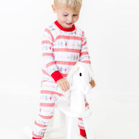 Little boy wearing personalized Modern Nutcracker Ballet for little boys with minimalistic images from the Nutcracker Ballet and his name with red checkered stripe pattern on white background and red cuffs.