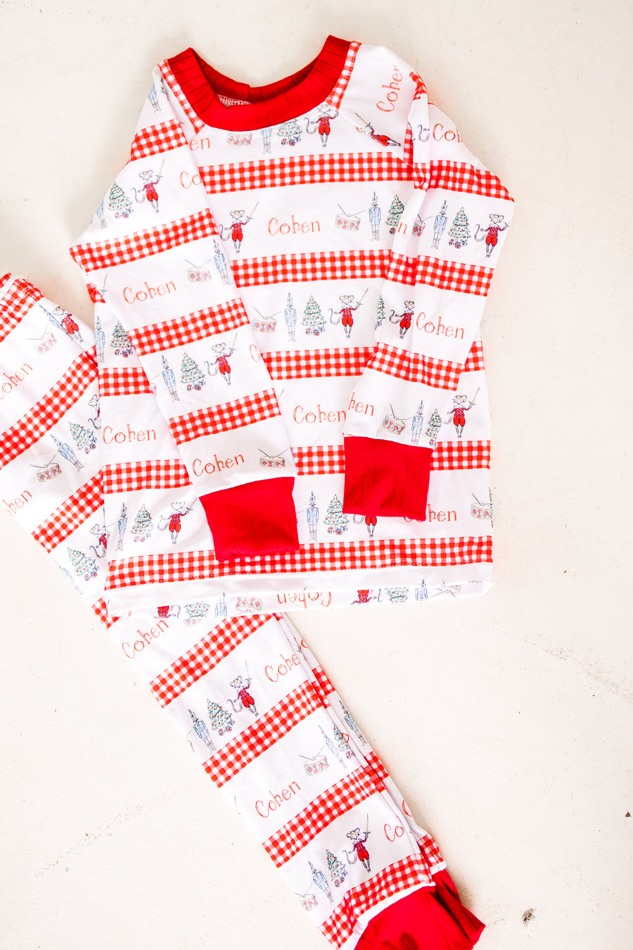 personalized Modern Nutcracker Ballet for little boys with minimalistic images from the Nutcracker Ballet and his name with red checkered stripe pattern on white background and red cuffs.