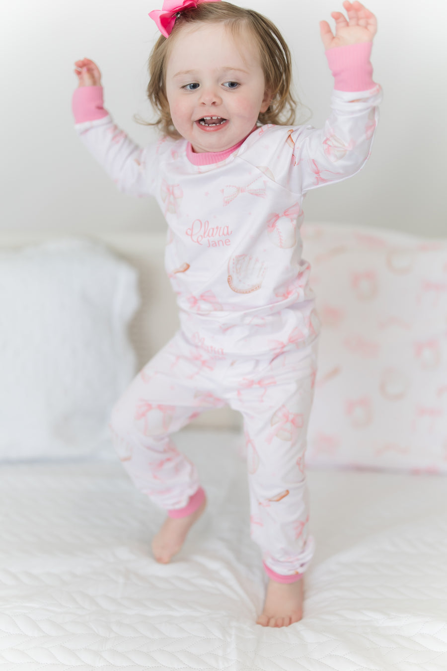 little girl wearing personalized baseball & bows light pink baseball theme pajamas