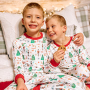 little boys wearing personalized Christmas pajamas featuring classic nutcracker images along with kid's name on white material and red cuffs.