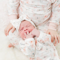 baby girl in peach blossom baby gown and matching headband, easy on and off outfit for newborn baby girl, personalized with baby's name and soft pink floral print