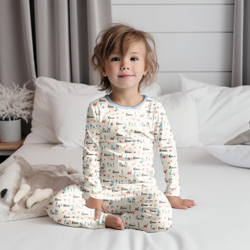 Little kid wearing personalized Christmas PJ's with nativity scene images and his or her name on soft ivory material.