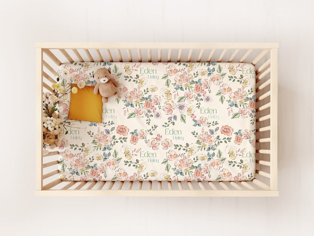 baby crib with personalized floral crib sheet with soft pastel colors on beige backgroud
