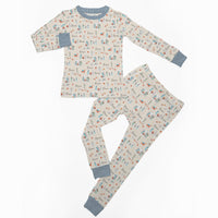 Little kid wearing personalized Christmas PJ's with nativity scene images and his or her name on soft ivory material.